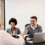 The multicultural businesspeople are sitting at the corporate fi A job interview at corporate firm on position of senior developer.